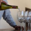 Wine being poured into a row of glasses
