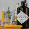 Hendricks gin on a table next to a cocktail